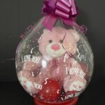 A pink teddy bear in a balloon with the words " i love you ".