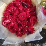 A bouquet of red roses with silver beads.