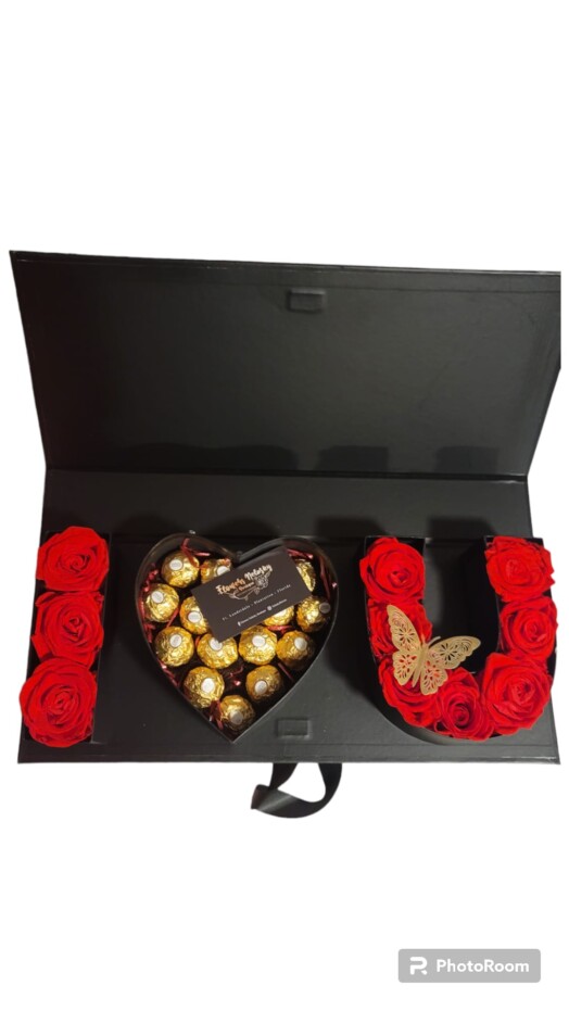 A heart shaped box of chocolates and roses