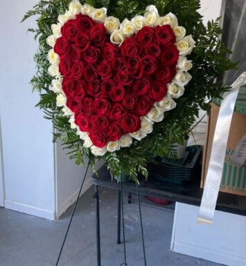 A heart shaped arrangement of roses on display.