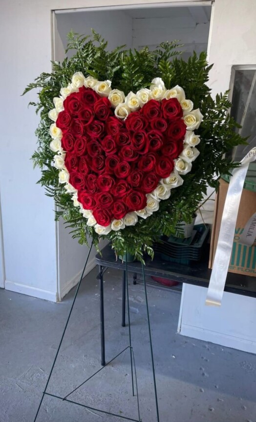 A heart shaped arrangement of roses on display.