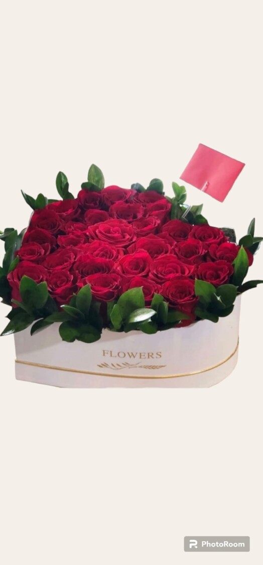 A box of roses with a note in front.