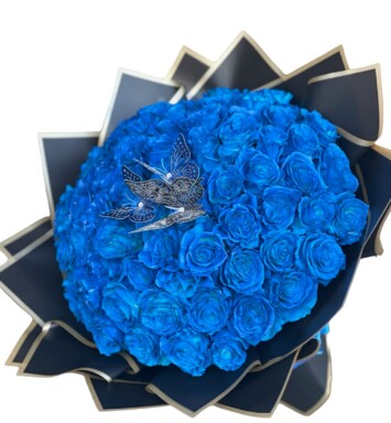 A bouquet of blue roses with a bird on top.