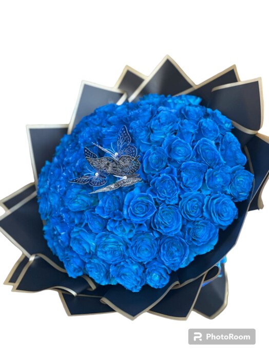A bouquet of blue roses with a bird on top.