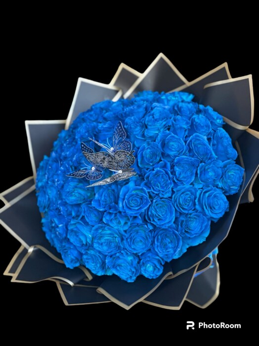 A bouquet of blue roses with a hummingbird on it.