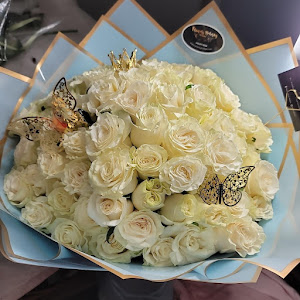 A bouquet of white roses with butterflies on top.